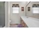 A bathroom with natural cabinets, solid surface counters, modern fixtures, a large mirror, and a walk-in shower at 933 Hummingbird Ln, Columbus, IN 47203