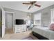 A bedroom with light gray walls, white trim, white windows, a bed, a ceiling fan, an area rug, and a writing desk at 933 Hummingbird Ln, Columbus, IN 47203