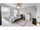 A bedroom with light gray walls, white trim, white windows, a bed, a ceiling fan, an area rug, and multiple decorations at 933 Hummingbird Ln, Columbus, IN 47203