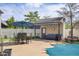 Charming pool cabana with awning, cozy seating, and adjacent patio area with outdoor dining at 933 Hummingbird Ln, Columbus, IN 47203