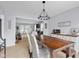 Dining area with a large wooden table, chandelier lighting, and views into the adjacent living area at 933 Hummingbird Ln, Columbus, IN 47203
