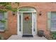 Charming front entrance featuring an arched doorway, a cheerful floral wreath, and stylish sconce lighting at 933 Hummingbird Ln, Columbus, IN 47203