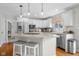 Spacious kitchen with white cabinets, stainless steel appliances, and center island with cooktop and seating at 933 Hummingbird Ln, Columbus, IN 47203