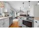 Open kitchen with stainless steel appliances, center island with cooktop, and a view of the living area at 933 Hummingbird Ln, Columbus, IN 47203