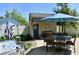 Outdoor patio area with a grill, dining table, and seating under a blue umbrella at 933 Hummingbird Ln, Columbus, IN 47203