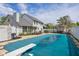 Large backyard pool area with diving board, patio, outdoor seating, and adjacent outbuilding at 933 Hummingbird Ln, Columbus, IN 47203