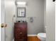 Compact powder room with a dark wood vanity, mirror, and modern lighting fixtures at 933 Hummingbird Ln, Columbus, IN 47203