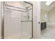 White tiled shower with glass door next to a soaking tub with marble floors at 950 Nevelle Ln, Carmel, IN 46032