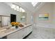 Bright bathroom with marble floors, dual sinks, skylight, and a soaking tub at 950 Nevelle Ln, Carmel, IN 46032