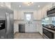Bright kitchen featuring white cabinets, stainless steel appliances, and a tile backsplash at 950 Nevelle Ln, Carmel, IN 46032