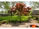 Well-maintained backyard with a fire pit, lush lawn, and landscaped garden beds at 961 Parkside Dr, Columbus, IN 47203
