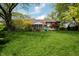 Spacious backyard featuring lush greenery, mature trees, and a covered patio, perfect for outdoor enjoyment at 961 Parkside Dr, Columbus, IN 47203