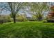 Expansive backyard featuring mature trees, lush lawn, and a private fence, creating a serene outdoor space at 961 Parkside Dr, Columbus, IN 47203