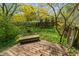 Tranquil backyard featuring a wooden deck, a charming wooden bench, and a lush garden area at 961 Parkside Dr, Columbus, IN 47203
