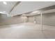 Unfinished basement with neutral carpet, white support beams, and a door with glass panels at 961 Parkside Dr, Columbus, IN 47203