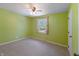 Bright bedroom features green walls, carpet flooring, and a sunlit window at 961 Parkside Dr, Columbus, IN 47203