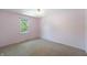 Cozy bedroom with pink walls, carpet flooring, and a bright window view at 961 Parkside Dr, Columbus, IN 47203