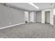 Unfinished basement with grey walls, carpet, and two doorways at 9829 Chambray Dr, Indianapolis, IN 46280