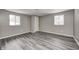 Bedroom with grey walls, two windows, and wood laminate floors at 9829 Chambray Dr, Indianapolis, IN 46280