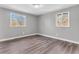 Bright bedroom featuring hardwood floors, neutral paint, and two windows for natural light at 9829 Chambray Dr, Indianapolis, IN 46280