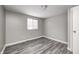 Bedroom with grey walls, window, and wood laminate floors at 9829 Chambray Dr, Indianapolis, IN 46280