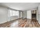 Spacious living room featuring hardwood floors, a window, and a white door leading to the outside at 9829 Chambray Dr, Indianapolis, IN 46280