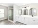 Modern bathroom boasts a glass-enclosed shower and double vanity with stylish mirrors at 10362 Delphi Ct, Fishers, IN 46038