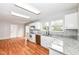 Modern kitchen with white cabinets, granite countertops, and hardwood floors at 10362 Delphi Ct, Fishers, IN 46038