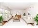 Bright living room featuring hardwood floors, two sofas, and decorative plants at 10362 Delphi Ct, Fishers, IN 46038