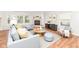 Bright living room with large windows, a cozy fireplace, and stylish, modern furniture at 10362 Delphi Ct, Fishers, IN 46038