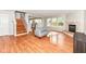 Bright living room with hardwood floors, fireplace, and staircase at 10362 Delphi Ct, Fishers, IN 46038