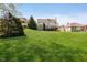 Large backyard featuring green grass, a multi-level deck, and mature trees surrounding the property at 10752 Tallow Wood Ln, Indianapolis, IN 46236