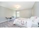 This bedroom features neutral walls, soft carpet, a drafting table, and a floral patterned comforter at 10752 Tallow Wood Ln, Indianapolis, IN 46236