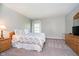 This bedroom features neutral walls, soft carpet, a window with natural light, and a floral patterned comforter at 10752 Tallow Wood Ln, Indianapolis, IN 46236