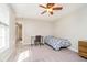 This bedroom features neutral walls, soft carpet, a ceiling fan, a small bed, and a desk at 10752 Tallow Wood Ln, Indianapolis, IN 46236