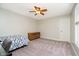 This bedroom features neutral walls, soft carpet, a ceiling fan, and a small bed at 10752 Tallow Wood Ln, Indianapolis, IN 46236