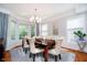 Bright dining room featuring elegant chandelier, large windows, and hardwood floors at 10752 Tallow Wood Ln, Indianapolis, IN 46236
