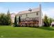 A view of the home's rear elevation and a wooden deck overlooking a lush lawn at 10752 Tallow Wood Ln, Indianapolis, IN 46236
