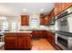 Traditional kitchen features stainless steel appliances, granite countertops, and cherry cabinets at 10752 Tallow Wood Ln, Indianapolis, IN 46236