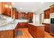 Updated kitchen showcases granite countertops, cherry wood cabinets, and stainless steel appliances at 10752 Tallow Wood Ln, Indianapolis, IN 46236