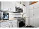 Kitchen featuring stainless steel appliances, sleek cooktop, white cabinets, and granite countertops at 11264 Fonthill Dr, Indianapolis, IN 46236