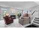 Bright living room with a cozy fireplace, staircase, large windows and neutral decor at 11264 Fonthill Dr, Indianapolis, IN 46236