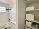 Well-lit bathroom with subway tile shower, granite vanity, and convenient built-in linen closet at 1136 Lawrence Ave, Indianapolis, IN 46227