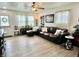 Inviting living room boasts wood flooring, ceiling fan, a comfortable leather sofa, and natural light at 1136 Lawrence Ave, Indianapolis, IN 46227