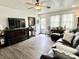Inviting living room boasts wood flooring, ceiling fan, a comfortable leather sofa, and natural light at 1136 Lawrence Ave, Indianapolis, IN 46227