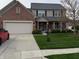 Charming two-story home featuring a well-manicured lawn and a combination of brick and vinyl siding at 11786 Ledgestone Cir, Fishers, IN 46037