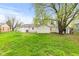 Spacious backyard with lush green grass, mature trees, and a storage shed offering ample space for recreation and storage at 1213 Fairview Dr, Greenfield, IN 46140
