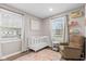 Inviting Bedroom with windows, crib, neutral walls and a cozy recliner at 1213 Fairview Dr, Greenfield, IN 46140