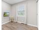 Bright bedroom with wood-look floors, window, curtains and mounted TV at 1213 Fairview Dr, Greenfield, IN 46140