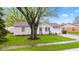 Quaint home with a manicured front yard, mature trees, and driveway leading to an attached garage at 1213 Fairview Dr, Greenfield, IN 46140